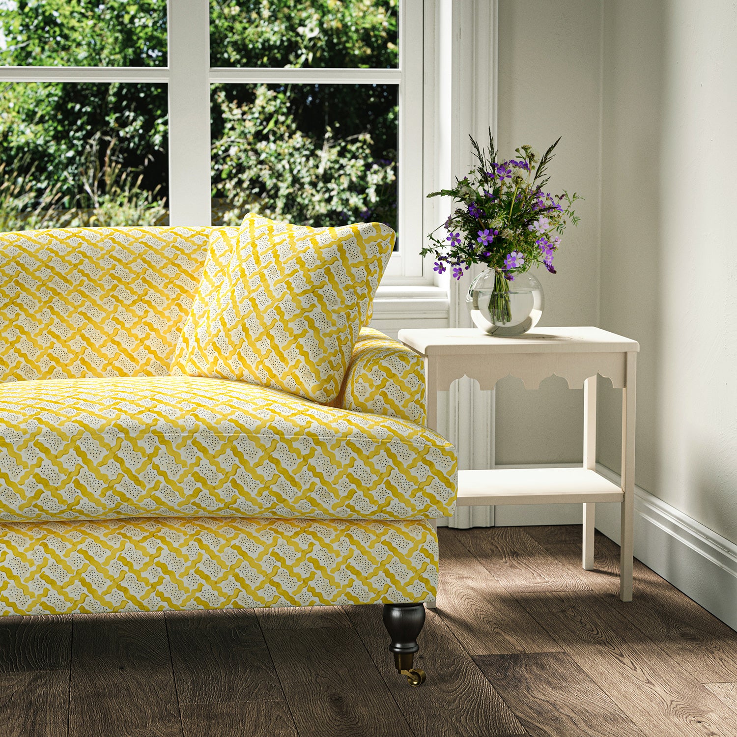 Printed linen fabric - a contemporary lattice design in yellow, cream and white – on a sofa