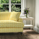 Printed linen fabric - a contemporary lattice design in yellow, cream and white – on a sofa