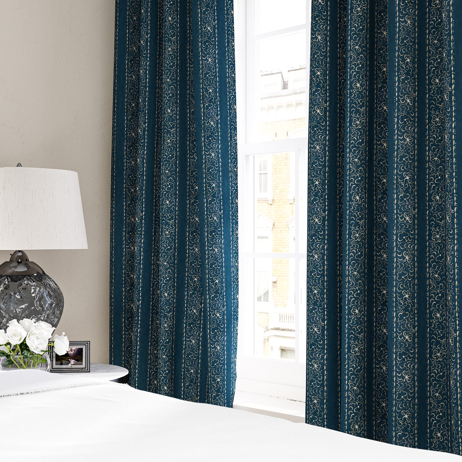Linen curtains with a delicate pattern of moons and star-like dots in blue and cream