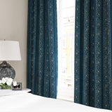 Linen curtains with a delicate pattern of moons and star-like dots in blue and cream