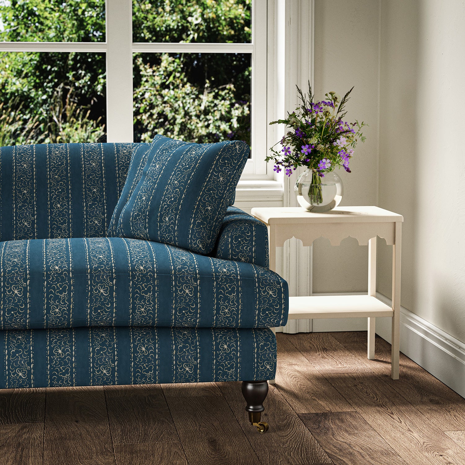 Printed linen fabric – a delicate pattern of moons and star-like dots in blue and cream – on a sofa