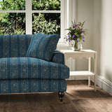 Printed linen fabric – a delicate pattern of moons and star-like dots in blue and cream – on a sofa
