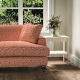 Printed linen fabric – damask-style pattern in red and cream – on a sofa