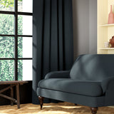 Living room featuring a sofa and curtains in a plain dark blue eco-friendly fabric