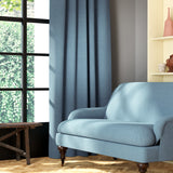 Living room featuring a sofa and curtains in a plain blue eco-friendly fabric