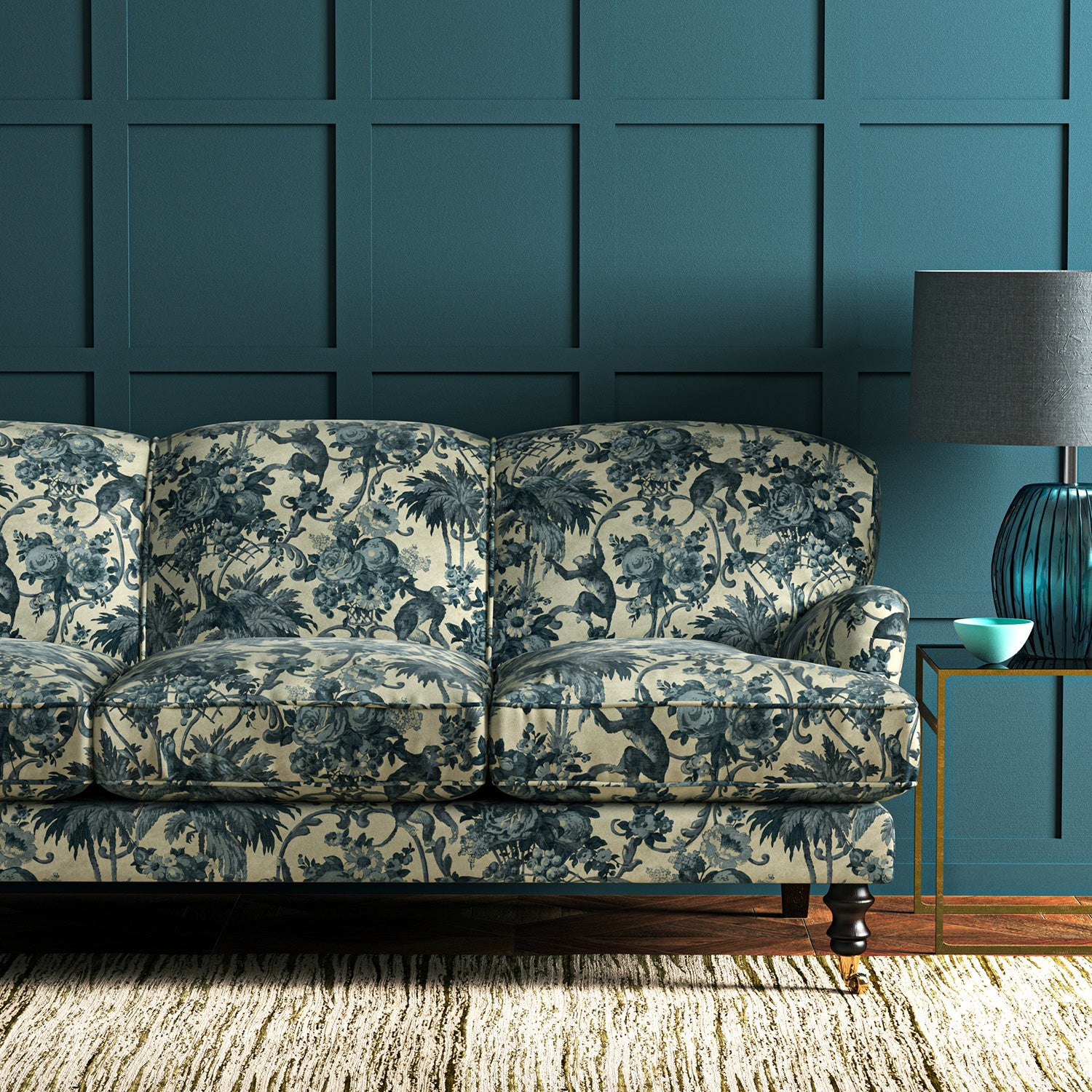 A printed velvet fabric showcasing a landscape of palms and monkeys in blue and cream on a sofa