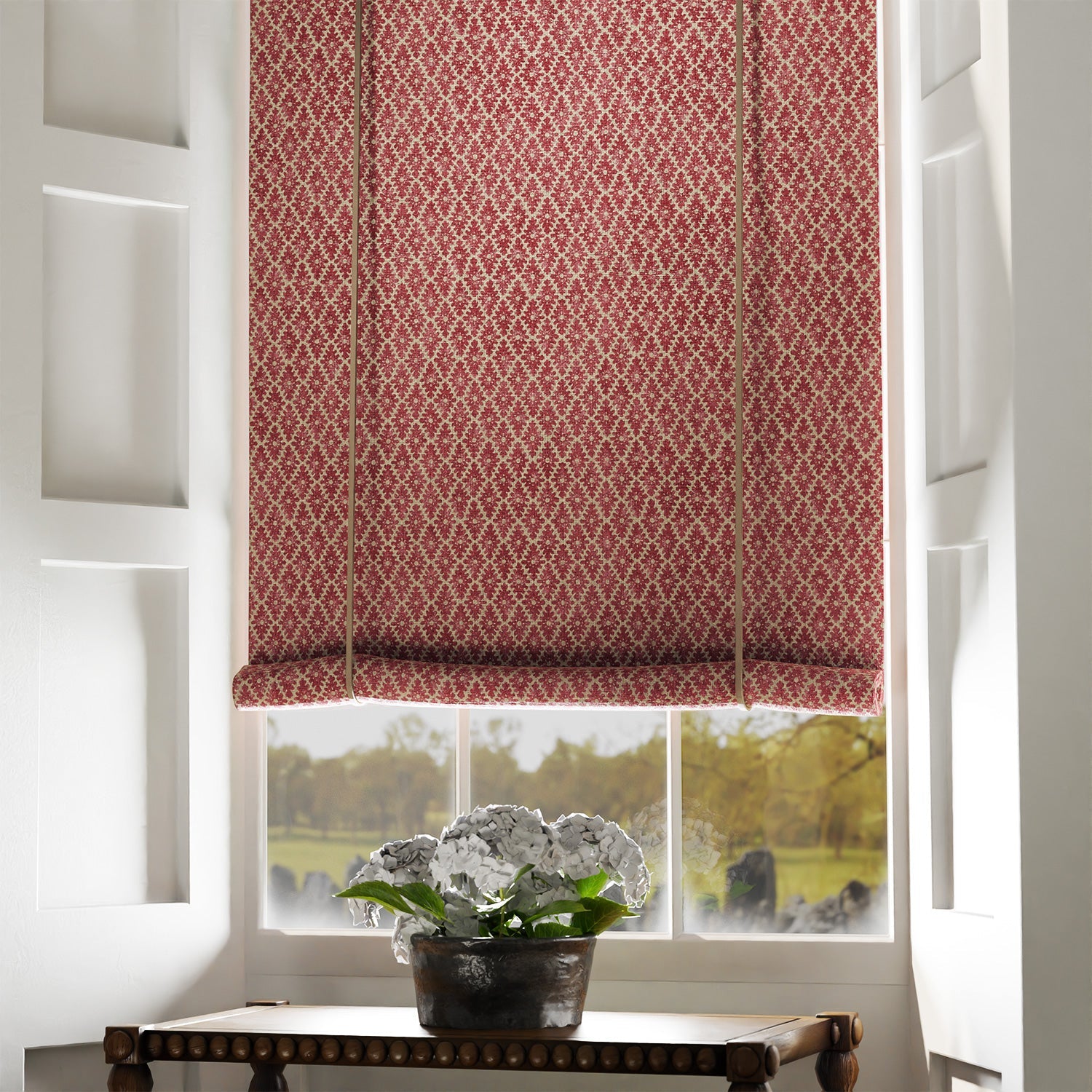 Blind in a red and neutral printed linen fabric with a geometric pattern