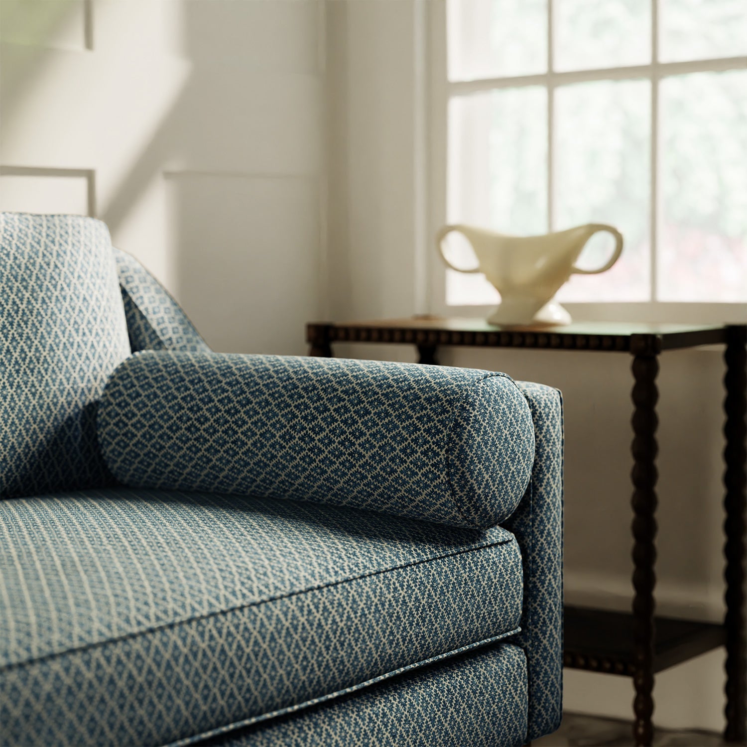 Sofa upholstered in a blue and neutral printed linen fabric with a geometric pattern
