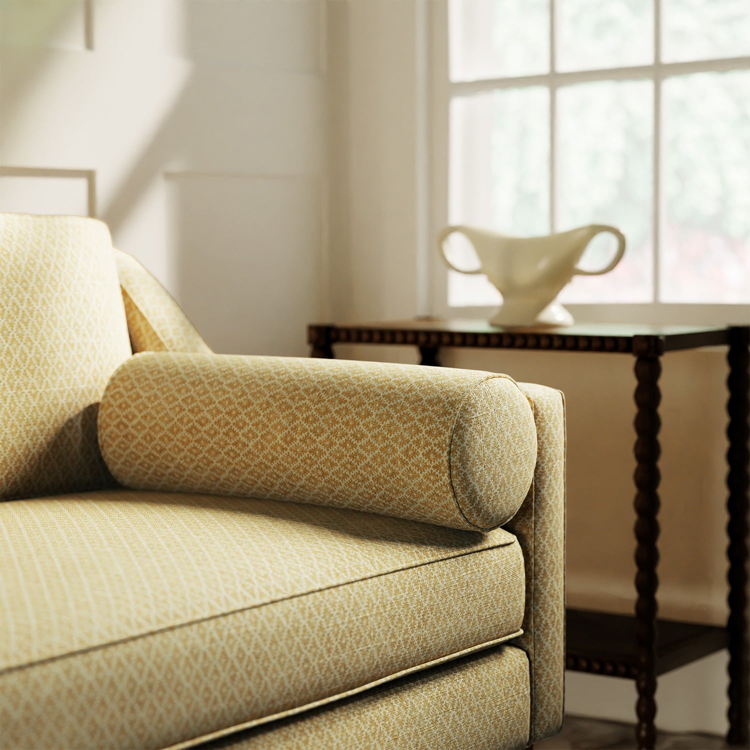 Sofa upholstered in a yellow and neutral printed linen fabric with a geometric pattern