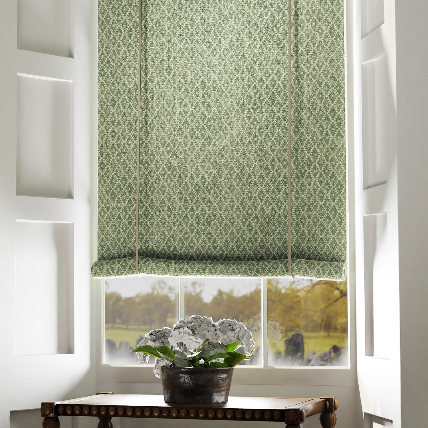 Blind in a green and neutral printed linen fabric with a geometric pattern