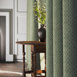 Curtains in a green and neutral printed linen fabric with a geometric pattern