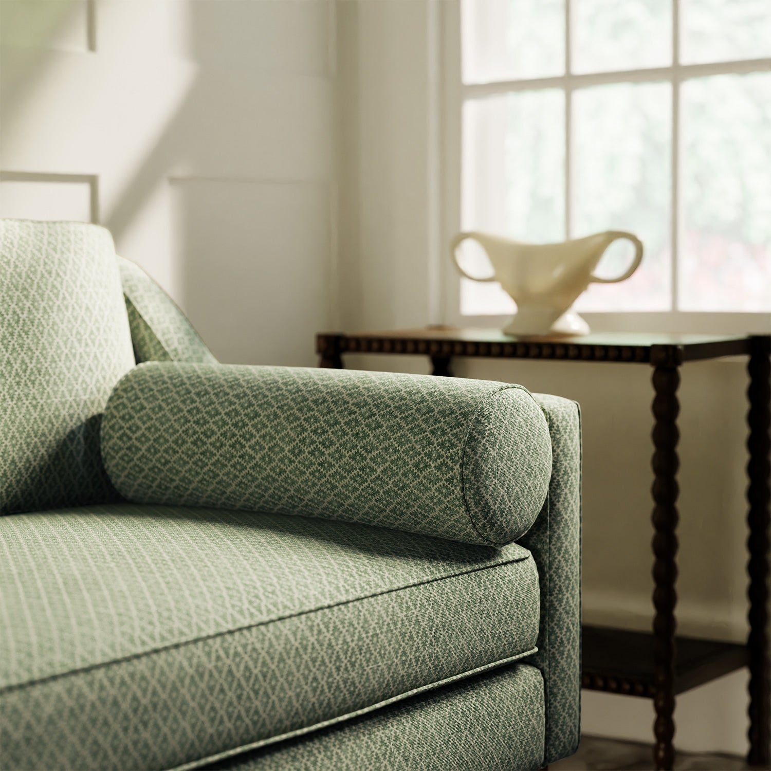 Sofa upholstered in a green and neutral printed linen fabric with a geometric pattern