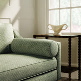 Sofa upholstered in a green and neutral printed linen fabric with a geometric pattern