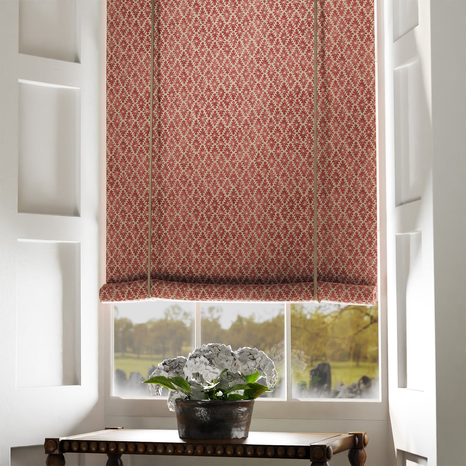 Blind in a red and neutral printed linen fabric with a geometric pattern