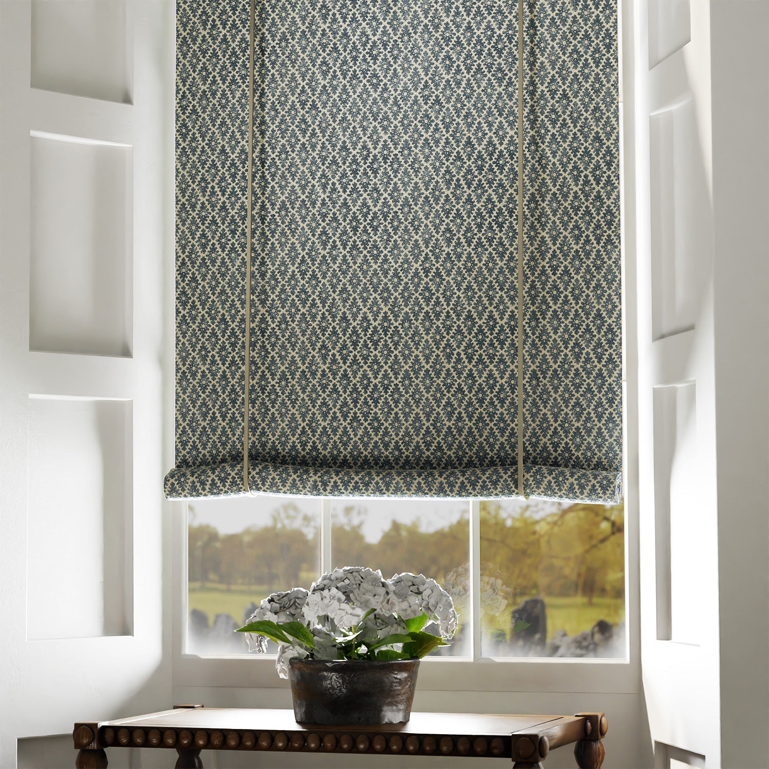 Blind in a blue and neutral printed linen fabric with a geometric pattern