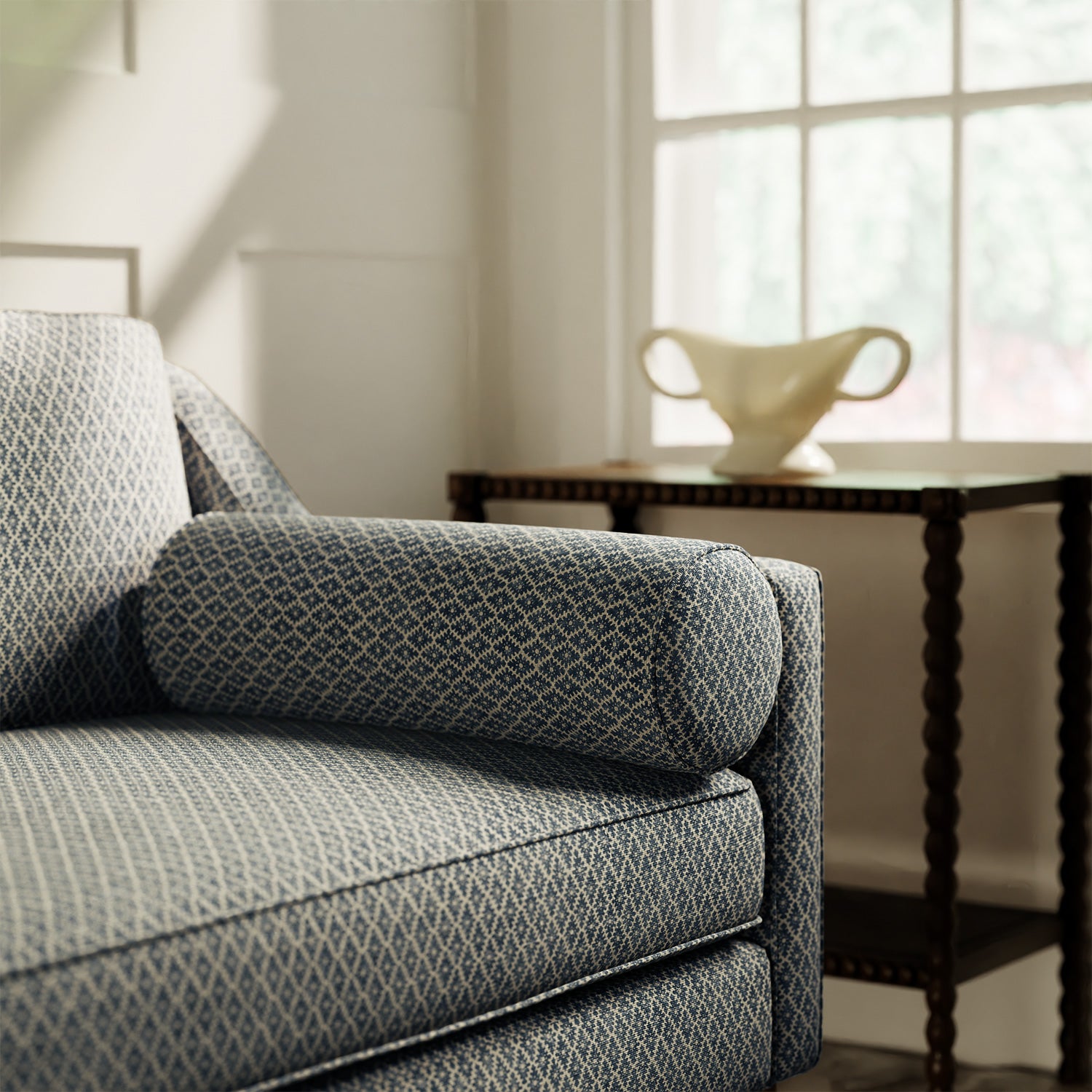 Sofa upholstered in a blue and neutral printed linen fabric with a geometric pattern