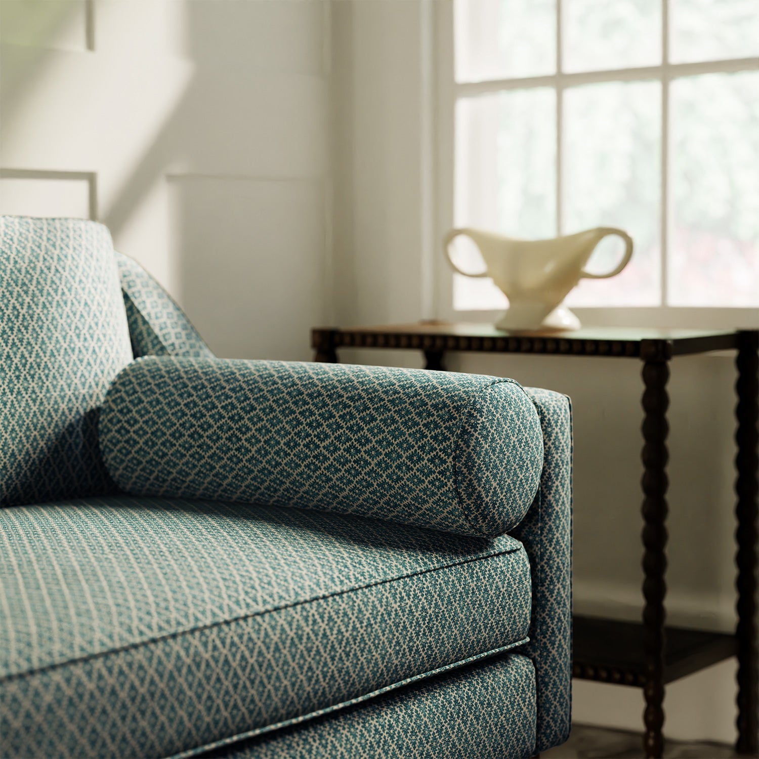 Sofa upholstered in a blue and neutral printed linen fabric with a geometric pattern