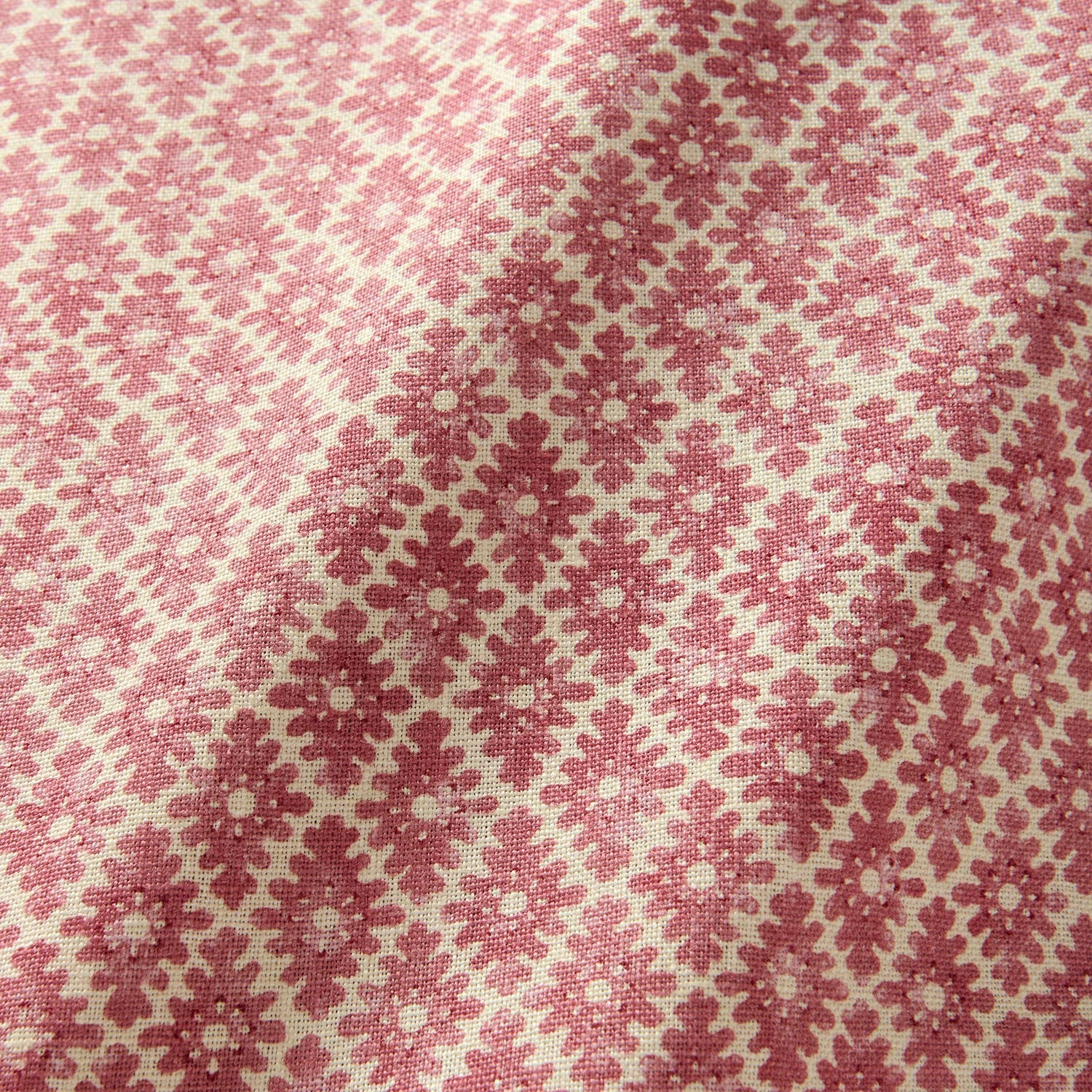 Fabric sample of a red and neutral printed linen fabric with a geometric pattern