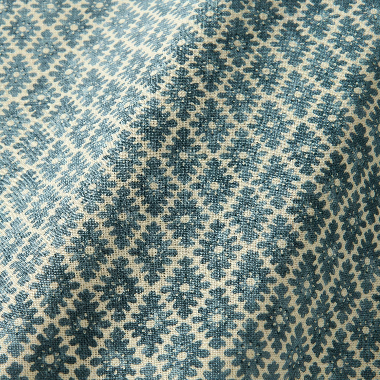 Fabric sample of a blue and neutral printed linen fabric with a geometric pattern