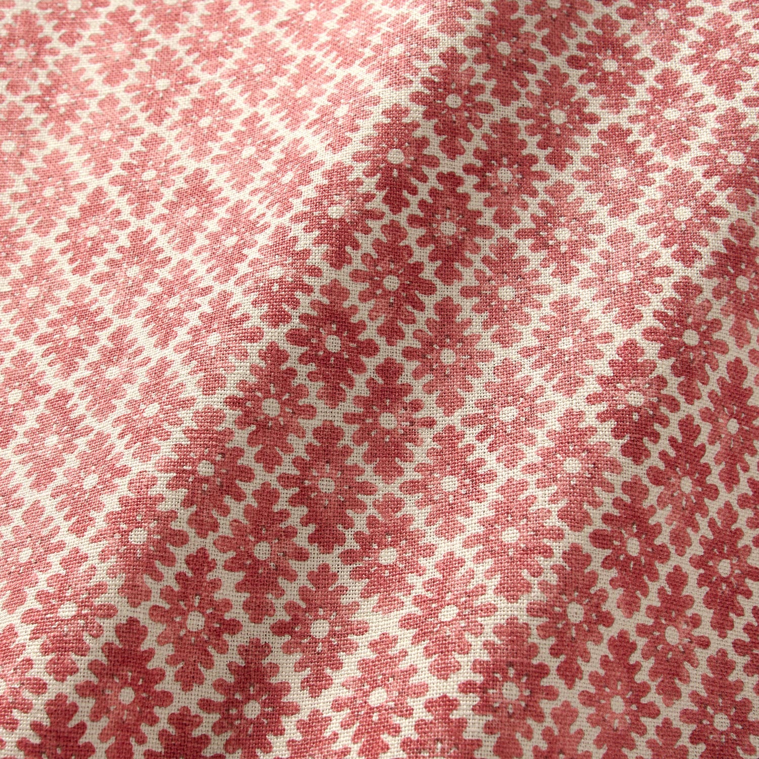 Fabric sample of a red and neutral printed linen fabric with a geometric pattern