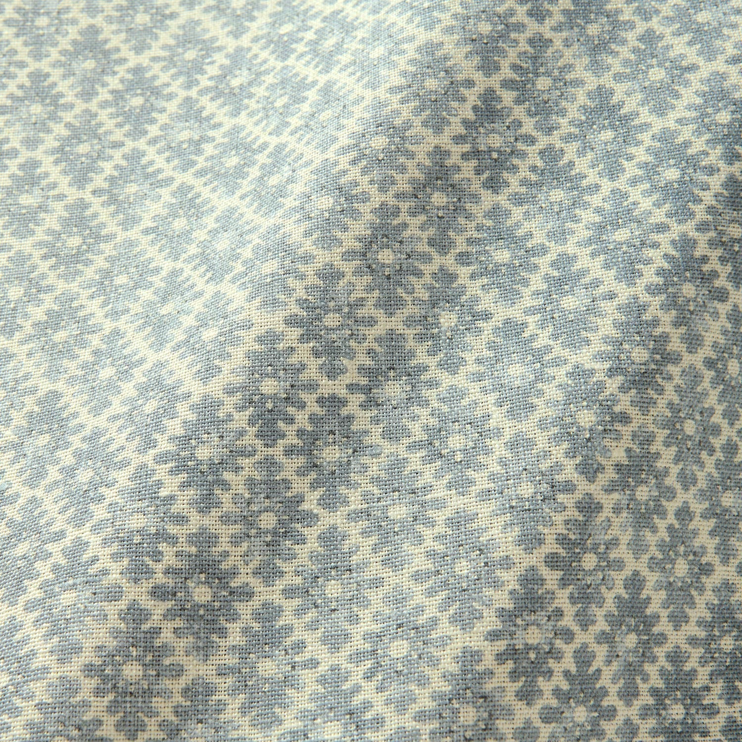 Fabric sample of a blue and neutral printed linen fabric with a geometric pattern