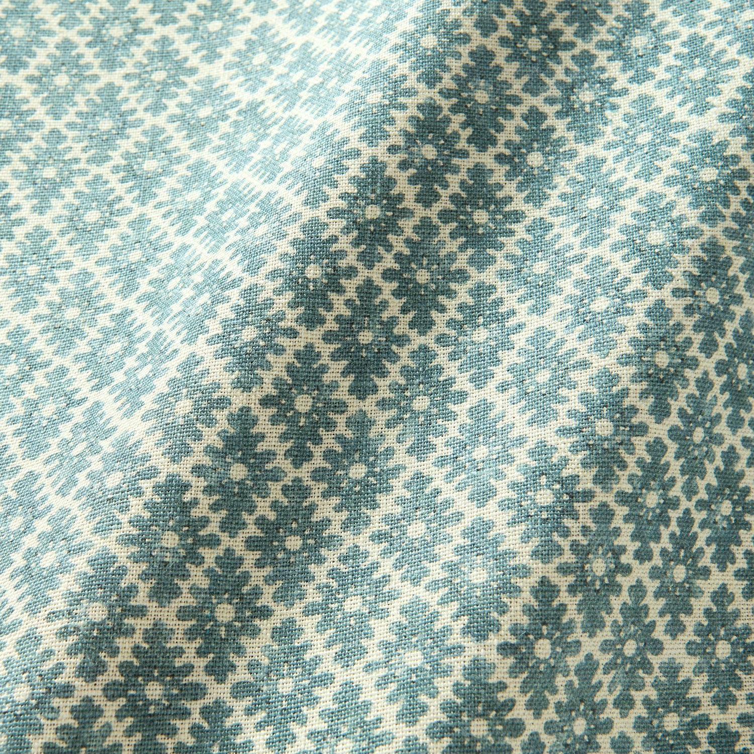 Fabric sample of a blue and neutral printed linen fabric with a geometric pattern