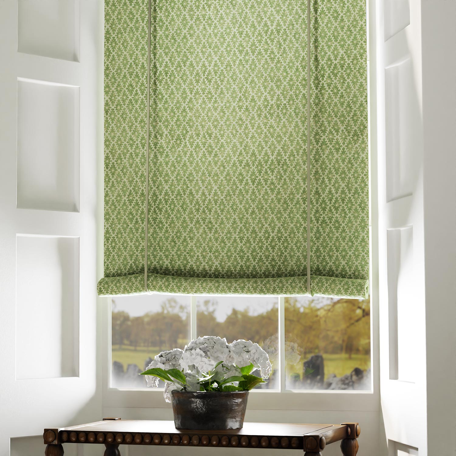 Blind in a green and neutral printed linen fabric with a geometric pattern