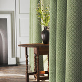 Curtains in a green and neutral printed linen fabric with a geometric pattern