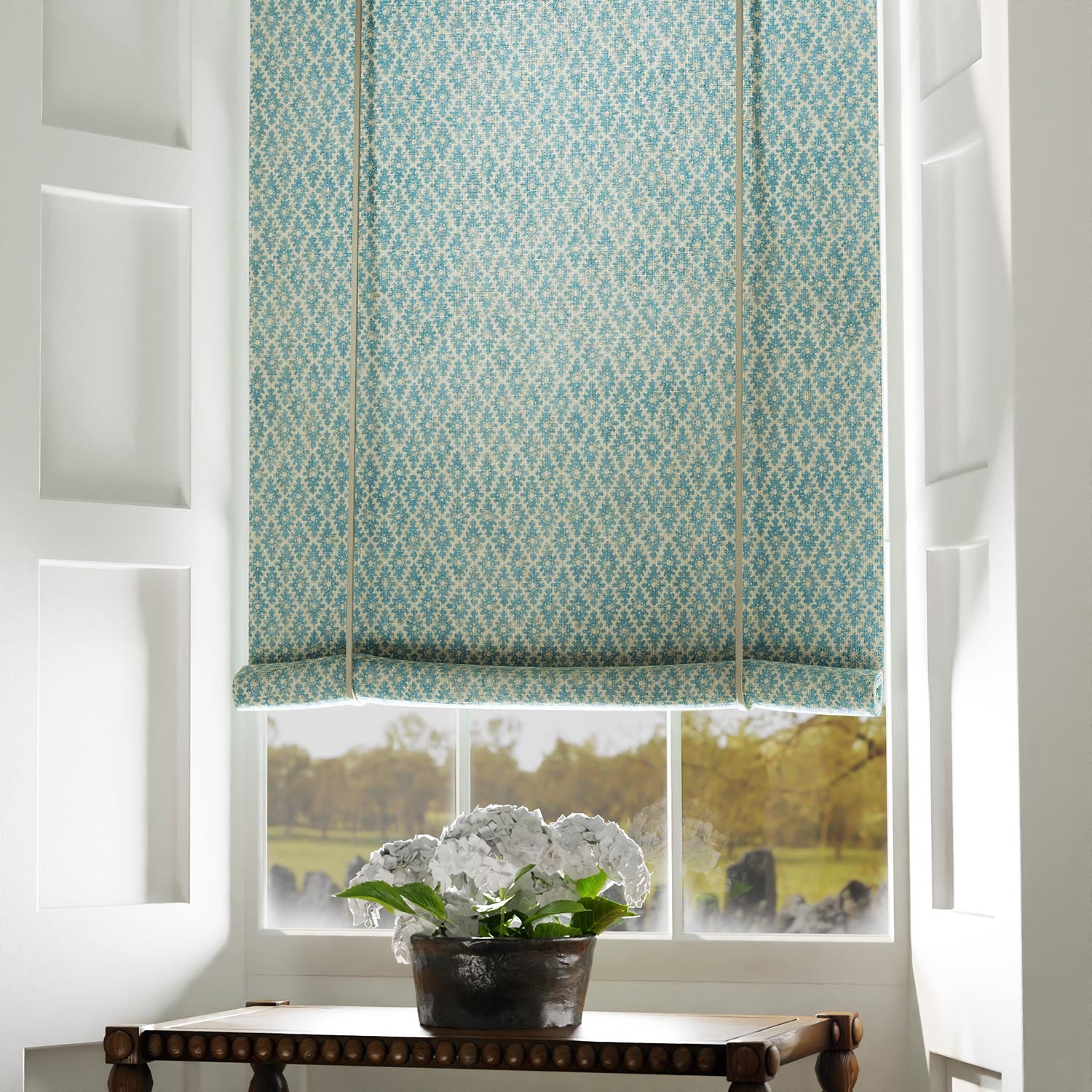 Blind in a blue and neutral printed linen fabric with a geometric pattern