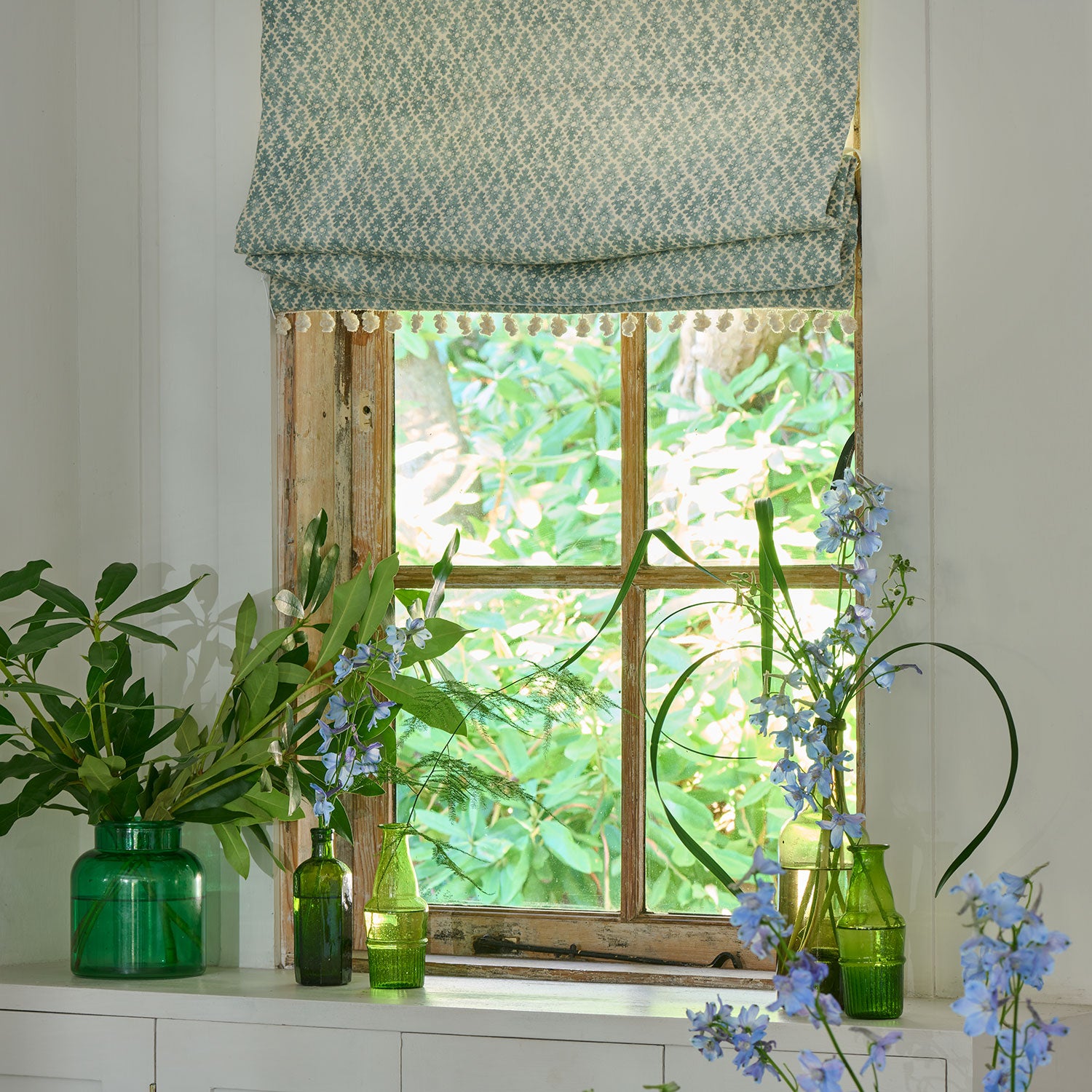 Blinds in a blue and neutral printed linen fabric with a geometric pattern