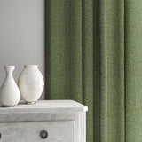 Green curtain made from a herringbone pure wool woven fabric.