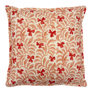 Decorative cushion with a red and pink floral pattern.
