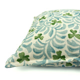 Decorative cushion with a pale blue and green floral pattern.