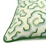 A green, blue and off white printed linen cushion with an animal style pattern.