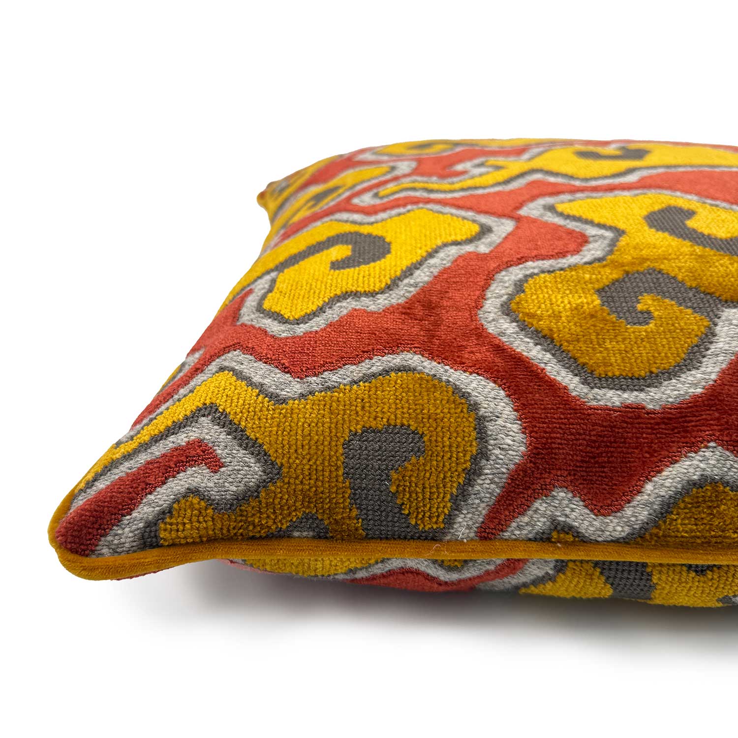 Close-up side view of Linwood cushion in Kumo Flame, showing the fabric texture and velvet piping detail.

