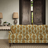 Sofa upholstered in a printed velvet fabric in brown and green featuring a stylized fern pattern.