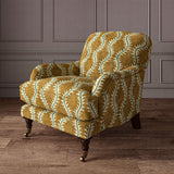 Armchair upholstered in a printed velvet fabric in brown and green featuring a stylized fern pattern.