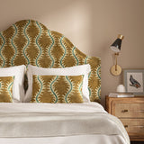 Headboard upholstered in a printed velvet fabric in brown and green featuring a stylized fern pattern.