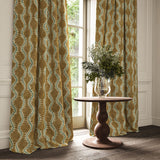 Curtains in a printed velvet fabric in brown and green featuring a stylized fern pattern.
