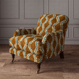 Armchair upholstered in a printed velvet fabric in brown and blue featuring a stylized fern pattern.