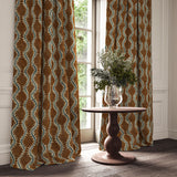 Curtains in a printed velvet fabric in brown and blue featuring a stylized fern pattern.