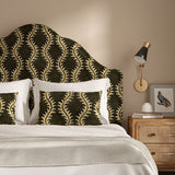 Headboard upholstered in a printed velvet fabric in brown and green featuring a stylized fern pattern.