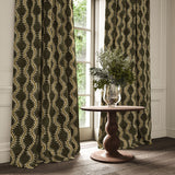 Curtains in a printed velvet fabric in brown and green featuring a stylized fern pattern.