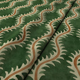 A printed velvet fabric sample in green and orange featuring a stylized fern pattern.