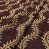 A printed velvet fabric sample in purple and orange featuring a stylized fern pattern.