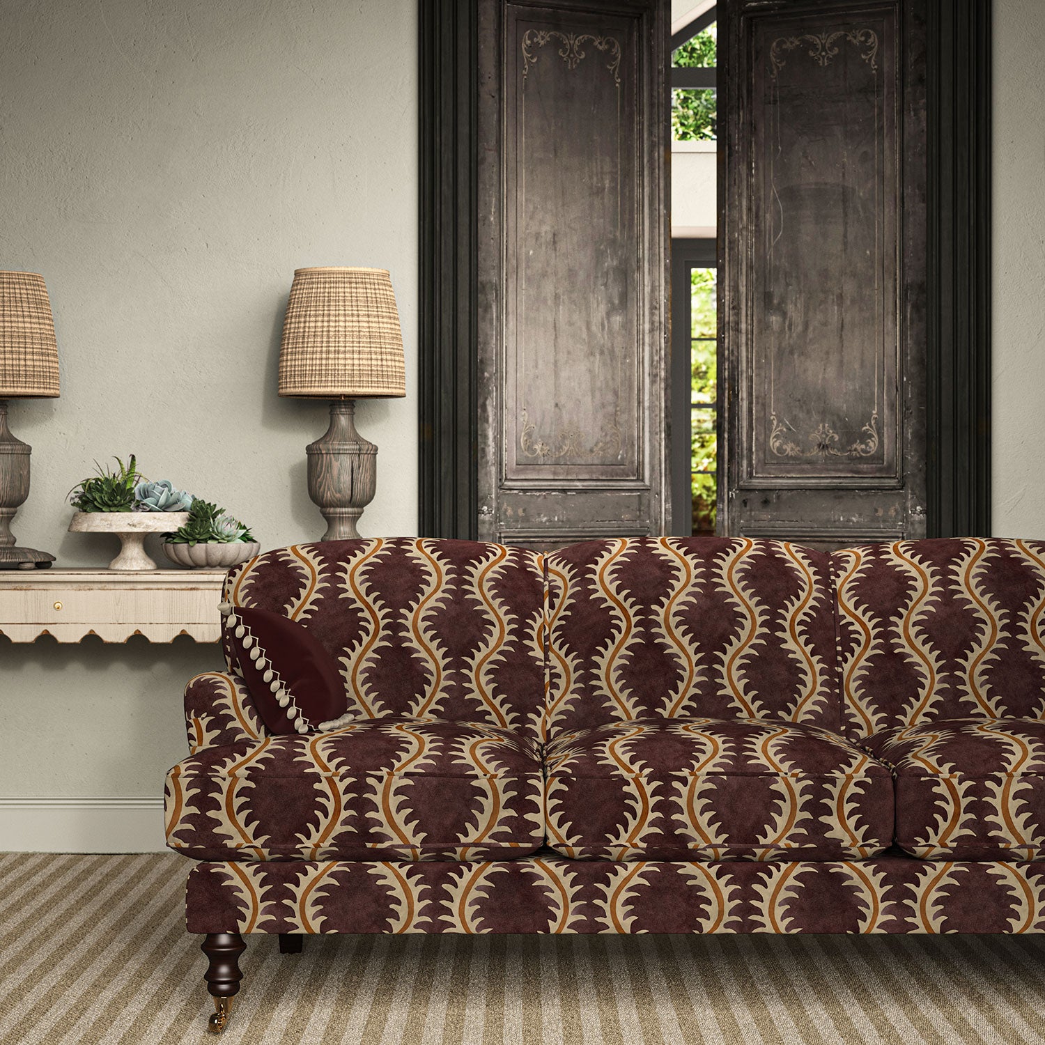 Sofa upholstered in a printed velvet fabric in purple and orange featuring a stylized fern pattern.