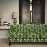 Sofa upholstered in a printed velvet fabric in green and blue featuring a stylized fern pattern.