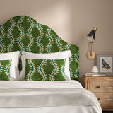 Headboard upholstered in a printed velvet fabric in green and blue featuring a stylized fern pattern.