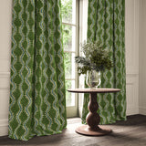 Curtains in a printed velvet fabric in green and blue featuring a stylized fern pattern.