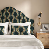 Headboard upholstered in a printed velvet fabric in blue and orange featuring a stylized fern pattern.